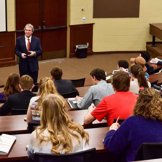 A speaker giving a lecture to a group of students